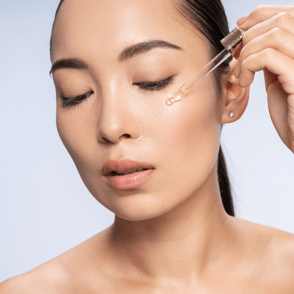 Asian woman applying her serum