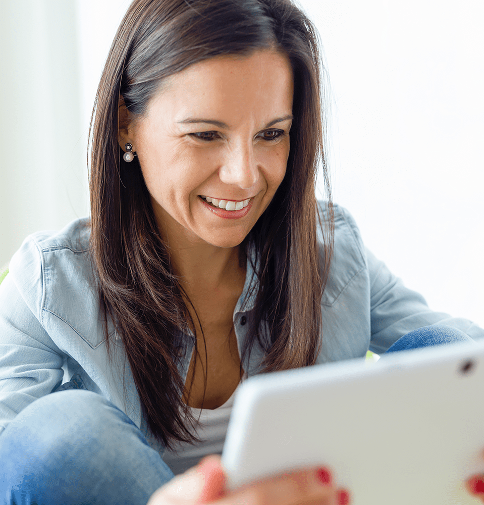 Woman looking at her mobile tablet and smiling